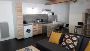 a living room with a couch and a kitchen at Entre terre et mer in Pornic