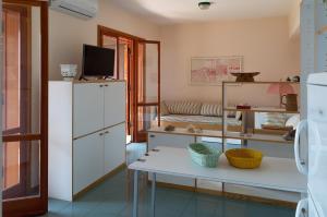 a living room with a white cabinet and a table at Beach House Blue Holiday in Letojanni +10 photos