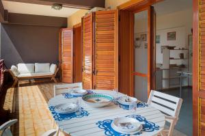 una sala da pranzo con tavolo e sedie bianchi di Beach House Blue Holiday a Letoianni