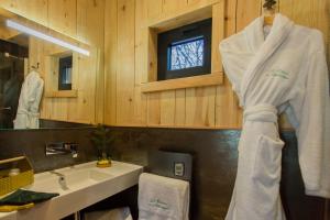 un bagno con lavandino e asciugamano appeso a un muro di Domaine de l'Authentique Cabanes dans les arbres a Fournet-Blancheroche