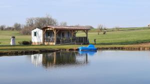 a small house with a blue boat in a lake at ETANG PRE DE LA FONT in Cercles