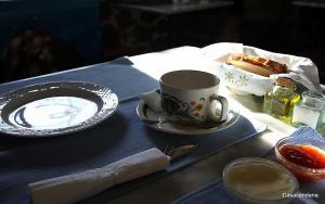 una mesa con una taza de café y un plato de comida en Casa Candana, en La Cándana de Curueño