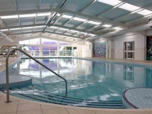 a large indoor swimming pool with blue water at Caravan Kensington 46 at Marton Mere Blackpool in Blackpool