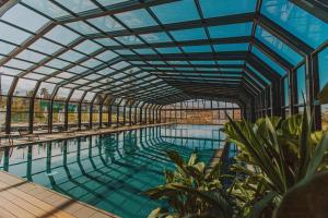 uma piscina interior com tecto de vidro em Tsinandali Estate, A Radisson Collection Hotel em Tsinandali