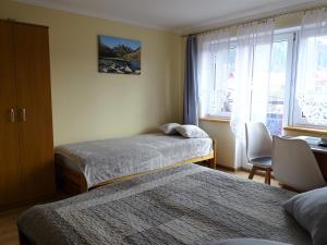 a hotel room with two beds and a window at Pokoje u Danusi in Sromowce Niżne