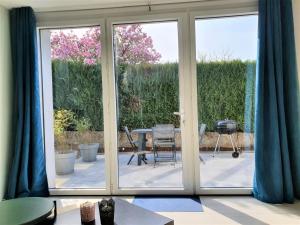 een glazen schuifdeur van een patio met een tafel en stoelen bij LA PIERRINA - Chamois - Appart 3 étoiles in Aix-les-Bains