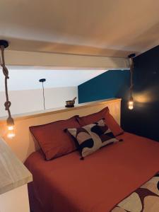 a bedroom with a bed with red sheets and blue walls at La Casita in Pouilly-le-Monial