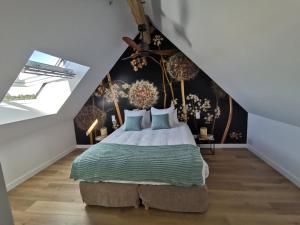 ein Schlafzimmer mit einem großen Bett im Dachgeschoss in der Unterkunft Une escale en Berry in Foëcy