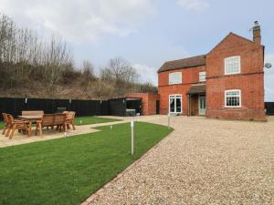 a house with a table and benches in the yard at Bankside House in Melton Mowbray