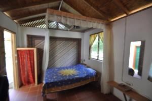 a bedroom with a bed in a room with windows at Castara Villas in Castara