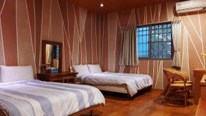una camera d'albergo con due letti e una finestra di Erfen De Homestay a Guanshan