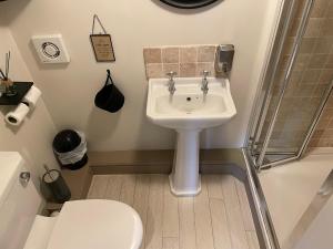 a bathroom with a white sink and a toilet at The Windmill Inn in Horsham +60 photos