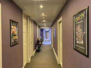 a hallway in a building with purple walls and a hallway with a hallway at Hôtel La Villa Lorraine in Toul