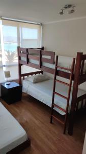 拉塞雷納的住宿－Hermoso apartamento de 2 dormitorios y 2 baños en Laguna del Mar La Serena，一间卧室设有两张双层床和梯子