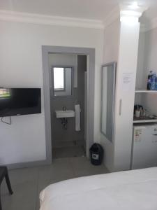 a white bedroom with a sink and a bathroom at Triple9 Hatfield Guesthouse in Pretoria +45 photos