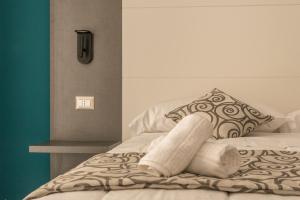 ein Bett mit Handtüchern und einem Kissen darauf in der Unterkunft FALERON Santa Lucia in Neapel