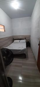 a bedroom with a bed in a white room at Hostel Em Boas Mãos in Barreirinhas