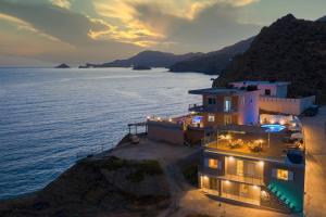 a building on the side of a cliff next to the ocean at Villa Melpomeni in Andiskárion