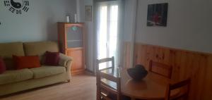 een woonkamer met een bank en een tafel bij Casa de Huespedes Onoba-Habitaciones in Huelva