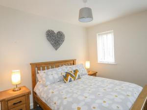 a bedroom with a bed with a heart on the wall at Swn Y Nant in Holyhead