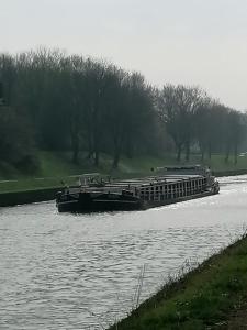 a boat on a river with trees in the background at Haus Lupo am Kanal in Castrop-Rauxel