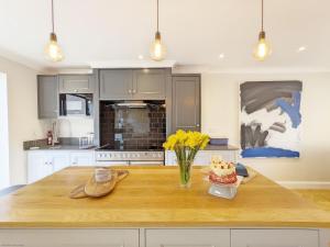 a kitchen with a wooden table with a cake on it at Steddles - Chichester in Chichester