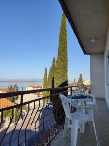 Un balcón con dos sillas blancas y una mesa. en Dream P-LEAce, en Crikvenica