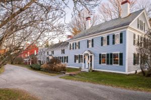 une maison bleue et blanche avec une allée dans l'établissement Inn at Valley Farms, à Walpole