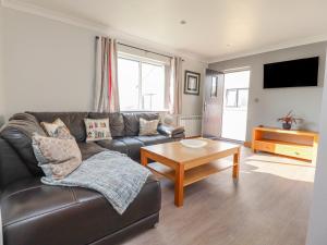 a living room with a leather couch and a coffee table at 2 Bedroom Annexe in Morecambe
