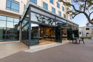 a glass building with tables and chairs in it at Somerset Westview Nairobi in Nairobi