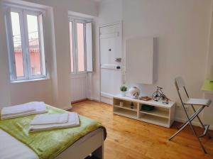 リスボンにあるEco Green Studio Apartmentの白い部屋(ベッド1台、椅子付)