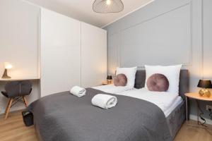 1 dormitorio con 1 cama grande con almohadas blancas y moradas en Browar Gdański Free Parking by Renters en Gdansk