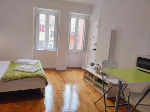 リスボンにあるEco Green Studio Apartmentのベッドとデスクが備わる客室です。