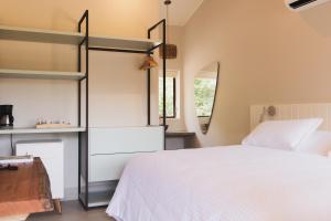 a bedroom with a white bed and a mirror at Øko Villa in Juquei
