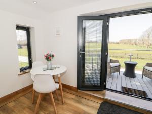 a room with a table and chairs and a sliding glass door at The Annexe in Llanfairpwllgwyngyll