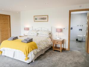 a bedroom with a bed and a bathroom with a shower at The Annexe in Llanfairpwllgwyngyll