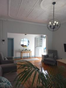 a living room with a couch and a chandelier at Triple9 Hatfield Guesthouse in Pretoria