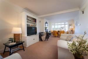 a living room with a couch and a tv at Uphigh - Elevated Family Home with Stunning River Views in Dartmouth