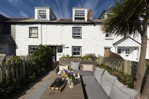 a white house with a fence and a patio at Mariners Cottage in Mousehole