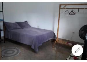 1 dormitorio con cama y soporte de madera en Edícula - Casa de hospedes - em Cananeia SP com ar condicionado en Cananéia