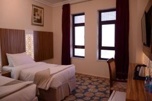 a hotel room with two beds and two windows at Artal International Hotel in Medina