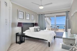 a bedroom with a bed with a view of the ocean at Driftwood 15 in Ballito