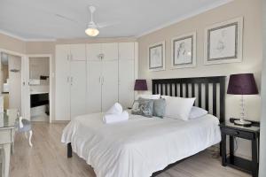 a bedroom with a large white bed and a desk at Driftwood 15 in Ballito