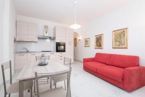 a living room with a red couch and a table at Rossi Tramonti 1, in Corniglia