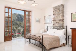 ein Schlafzimmer mit einem Bett und einer Steinmauer in der Unterkunft Rossi Tramonti 1, in Corniglia