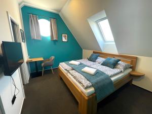 Schlafzimmer mit einem Bett mit blauer Wand in der Unterkunft Penzion Nad Lávkou in Uherský Brod