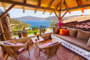 a porch with a couch and chairs and a view of the ocean at Fidanka Hotel in Kalkan