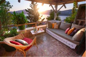 a couch on a patio with a view of the water at Fidanka Hotel in Kalkan