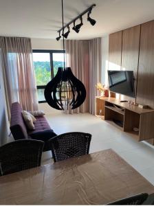 uma sala de estar com um sofá e uma televisão em Condomínio Paraiso dos Coqueiros em Camaçari