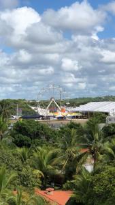 a ferris wheel in a amusement park with palm trees at Condomínio Paraiso dos Coqueiros in Camacari